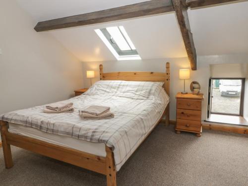 een slaapkamer met een bed, 2 lampen en een raam bij Hayloft in Staintondale