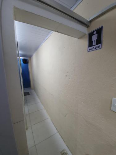 a hallway with a restroom sign on a wall at Pousada das Artes 2 in Mongaguá