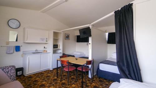 a small room with a table and a bed at Whangarei Central Holiday Park in Whangarei