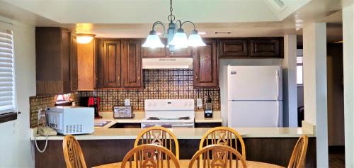 a kitchen with a white refrigerator and wooden cabinets at High Sierra Condominiums in Ruidoso