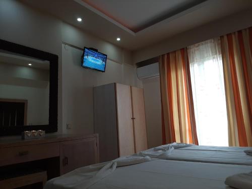 a bedroom with a bed and a television on the wall at Mamas Reas in Káto Spílaion