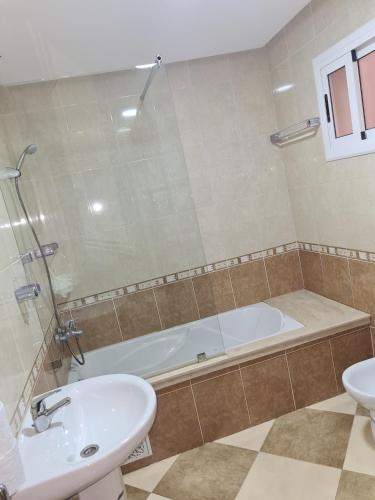 a bathroom with a bath tub and a sink at RESIDENCE LA CORNICH in Nador