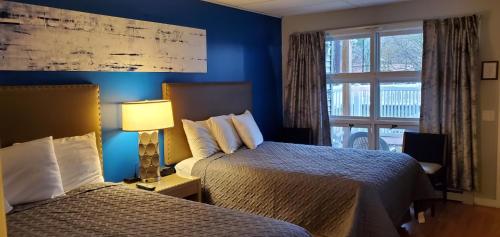 a hotel room with two beds and a window at Lido Motel Lake George in Lake George