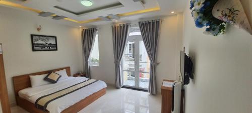 a bedroom with a bed and a large window at Peony Hotel in Da Lat