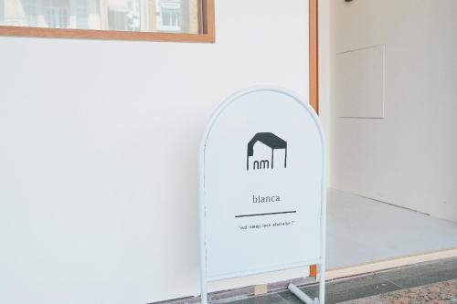a sign for a hotel against a white wall at Bianca in Tainan