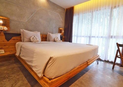 a bedroom with a large bed with a large window at Greenhost Boutique Hotel Prawirotaman in Yogyakarta