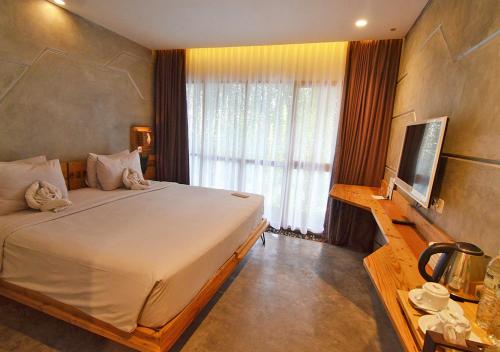 a bedroom with a large bed and a television at Greenhost Boutique Hotel Prawirotaman in Yogyakarta