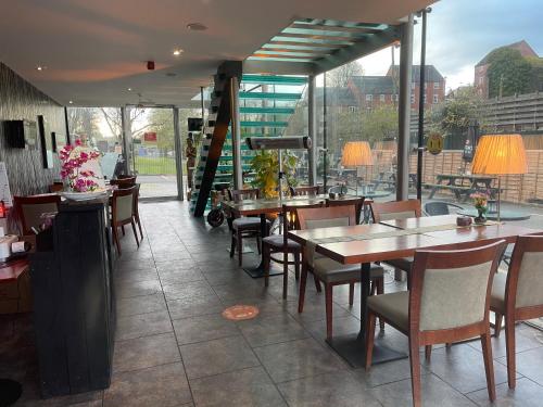 um restaurante com mesas e cadeiras e um pátio em The Old Mill Thai vintage em Whitchurch