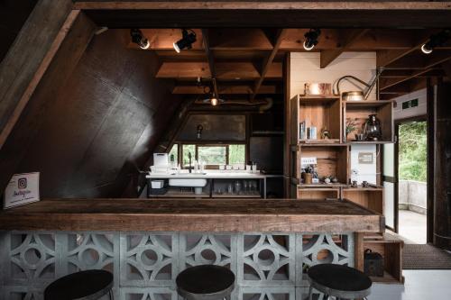 a kitchen with a counter and some stools at LOGIN OKINAWA -wood- in Onna