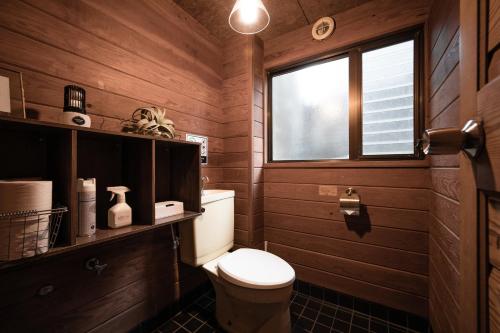 a bathroom with a toilet and a window at LOGIN OKINAWA -wood- in Onna