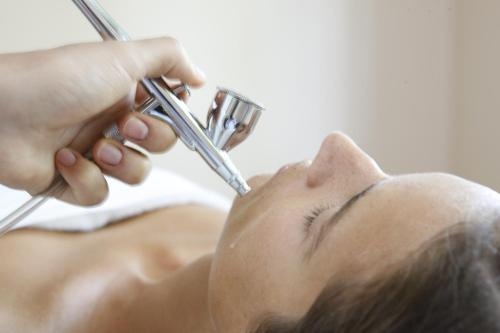 a woman getting her hair cut with a razor at L'Albereta Relais & Chateaux in Erbusco
