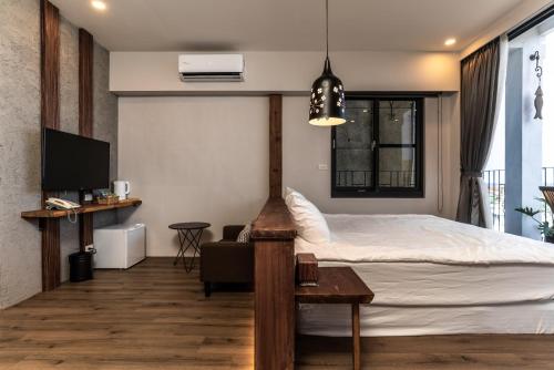 a bedroom with a bed and a tv and a couch at Marbordo B&B in Xiaoliuqiu