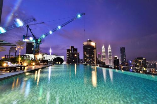 a swimming pool with a city skyline at night at Dorsett Residences Bukit Bintang @Artez Maison in Kuala Lumpur