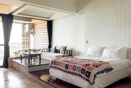 sypialnia z łóżkiem, stołem i kanapą w obiekcie Daban Six Guest House w mieście Nanwan