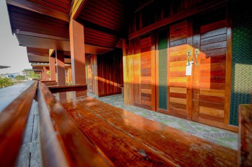 a wooden bench in front of a building at MRK Resort & Massage in Lop Buri