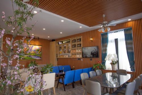 a dining room with a table and blue chairs at Win Villa Coffee in Da Lat