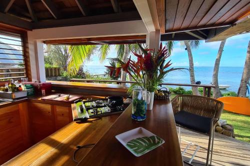 a kitchen with a table with a view of the ocean at Villa Oona in Maharepa