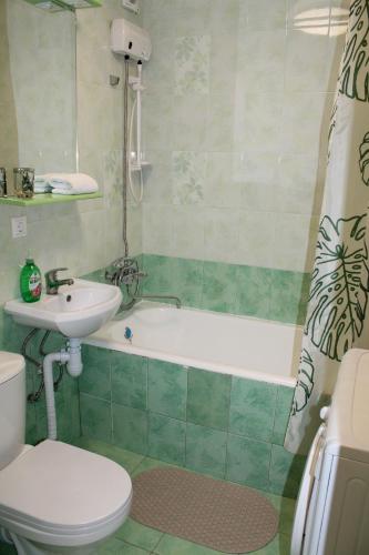 a bathroom with a toilet and a tub and a sink at Амурский бульвар 5, Семейные Апартаменты в районе набережной in Khabarovsk
