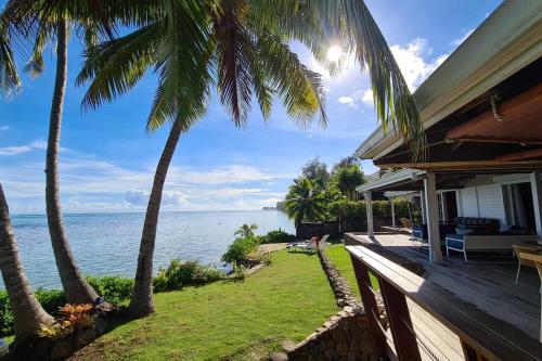 a house with palm trees and a view of the ocean at Villa Oona in Maharepa