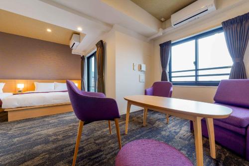 a hotel room with a bed and a table and chairs at RESI STAY Gojozaka in Kyoto