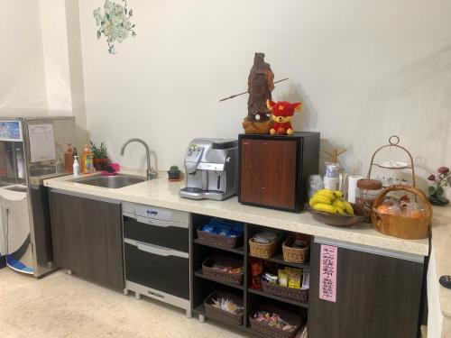 a kitchen with a sink and a counter top with food at 伯爵四季休閒民宿 in Jinhu
