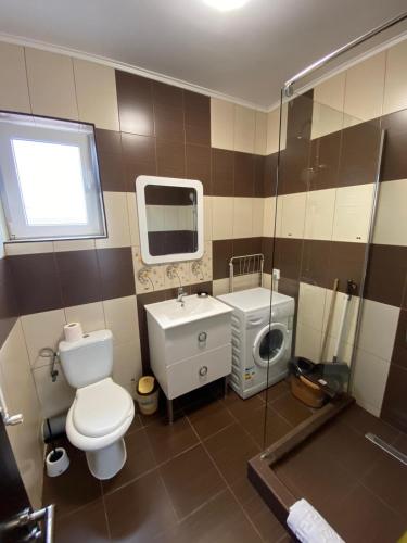 a bathroom with a toilet and a sink and a shower at Apartament Ella T8 in Mamaia Sat/Năvodari