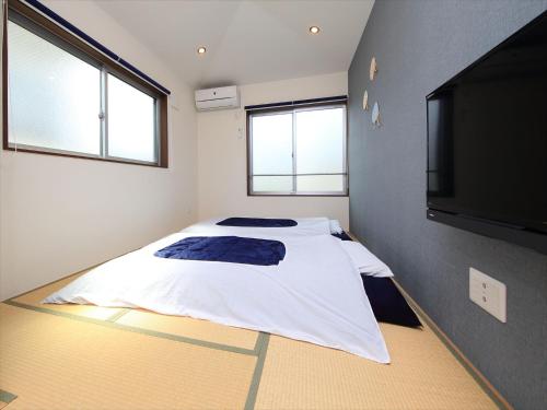a bedroom with a bed and a flat screen tv at COTO Tokyo Shibuya 4 in Tokyo