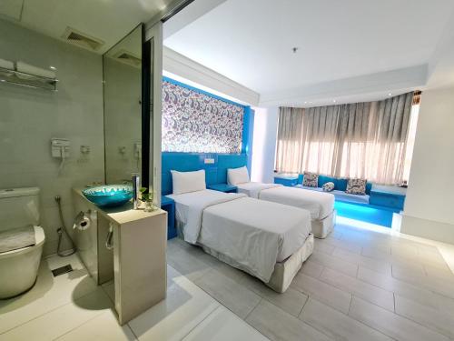 a hotel room with two beds and a bathroom at Arenaa Star Hotel in Kuala Lumpur