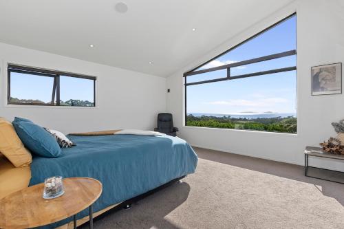 a bedroom with a bed and a large window at Tutukaka Vista - Tutukaka Holiday Home in Tutukaka