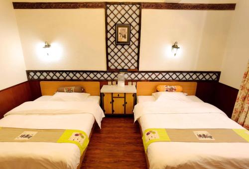 two beds in a hotel room with twothirdsessions at Gaisang Mêdog Aroma Fragrance Hotel in Lhasa