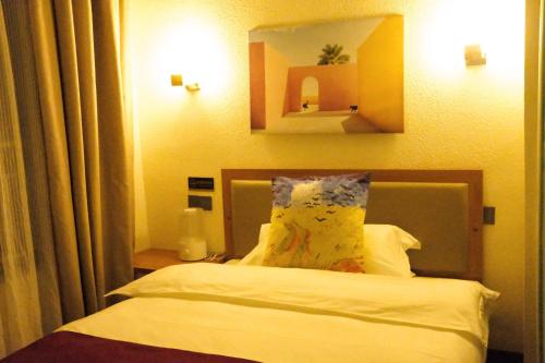 a hotel room with a bed with a pillow on it at Gaisang Mêdog Aroma Fragrance Hotel in Lhasa