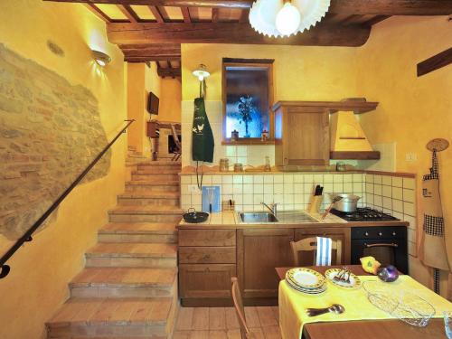 eine Küche mit einer Treppe und einem Tisch sowie eine Küche mit einem Tisch in der Unterkunft Belvilla by OYO Il Rigogolo in SantʼAngelo in Pontano