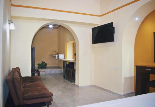 a living room with a couch and a tv on a wall at Hotel Casa Rico in Valladolid