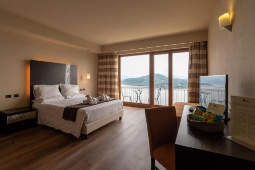a bedroom with a bed and a balcony with a view at Hotel Ristorante San Carlo in Arona