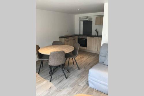 - une cuisine et une salle à manger avec une table et un canapé dans l'établissement Côté Dune - Maison (3P) au calme proche de la mer, à Barneville-Carteret