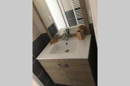 une salle de bain avec un lavabo et un miroir dans l'établissement Côté Dune - Maison (3P) au calme proche de la mer, à Barneville-Carteret