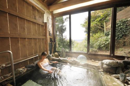 下田市にあるWelcome Inn SunnyStepsの家の湯船に入る女