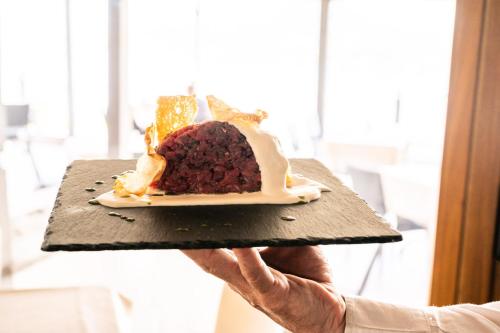 a person holding up a plate of food at Hotel Ristorante San Carlo in Arona