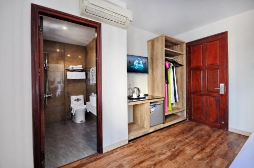 uma casa de banho com um WC e uma porta de vidro em Golden Lotus Hotel em Nha Trang