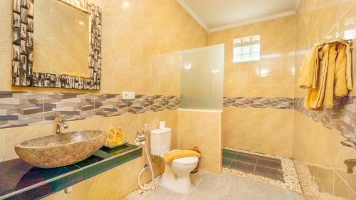 uma casa de banho com um lavatório e um WC em Abhirama Villas by Supala em Ubud