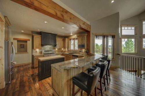 a kitchen with a large island with bar stools at Bear Discovery Custom Tamarack Estate Home by Casago McCall - Donerightmanagement in Donnelly