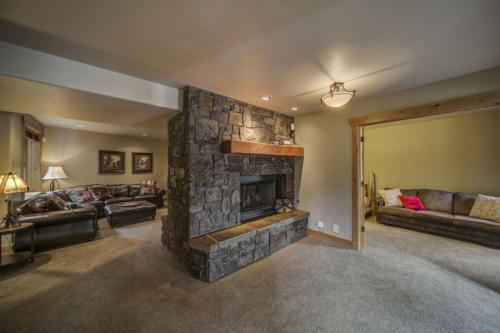 a living room with a stone fireplace in a house at Bear Discovery Custom Tamarack Estate Home by Casago McCall - Donerightmanagement in Donnelly