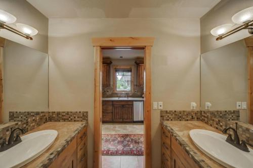 a bathroom with two sinks and two mirrors at Bear Discovery Custom Tamarack Estate Home by Casago McCall - Donerightmanagement in Donnelly