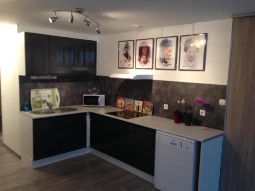 une cuisine avec des armoires noires et un comptoir dans l'établissement Le Sweet Home Lens, à Lens