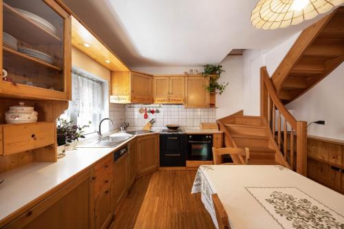 a kitchen with wooden cabinets and a staircase at Ciasa Goti in Moena