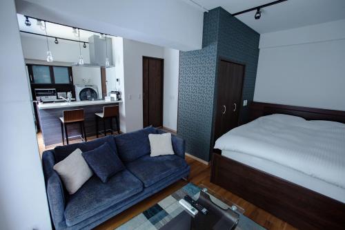 1 dormitorio con cama, sofá y cocina en NIYS apartments 03 type en Tokio