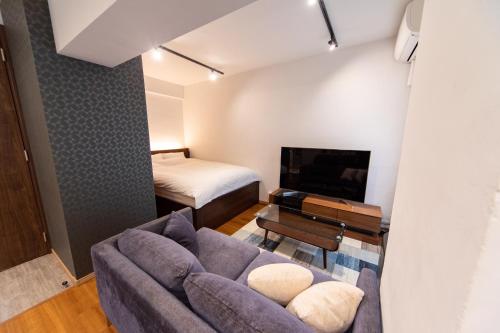 a living room with a couch and a bed at NIYS apartments 03 type in Tokyo