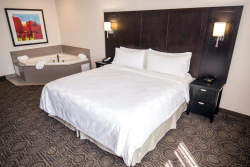 a hotel room with a bed and a bath tub at Holiday Inn Hotel & Suites Red Deer by IHG in Red Deer
