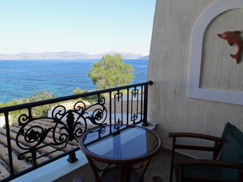 a glass table on a balcony with a view of the ocean at Dionysos Hotel in Skala