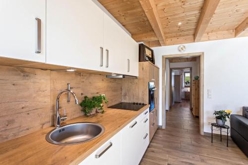 a kitchen with white cabinets and a sink at Ferienwohnung Rupertiwinkl in Teisendorf